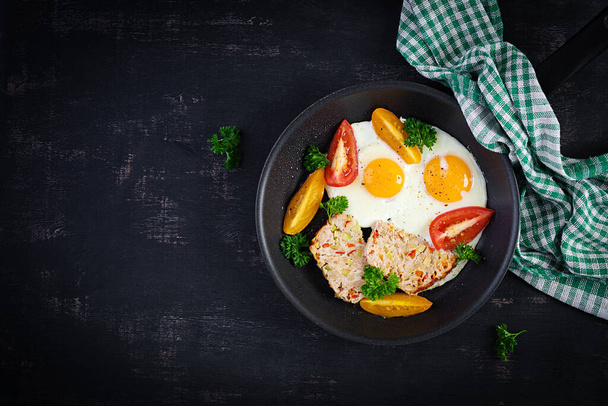 Тарелка с кето диетической пищей. Жареное яйцо, мясной рулет и помидоры. Кето, Палео завтрак. Вид сверху, плоский - Фото, изображение