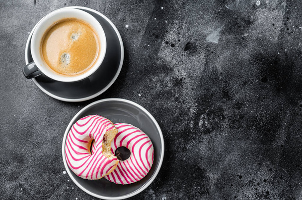 Рожеві глазуровані пончики з чашкою кави, Дагхат. Чорний фон. Краєвид. Копіювальний простір - Фото, зображення