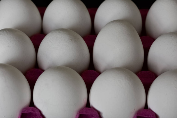 Λευκά αυγά κοτόπουλου σε μαύρο φόντο. - Φωτογραφία, εικόνα