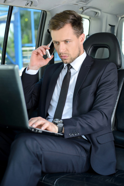 Young successful businessman riding in the car - Foto, imagen