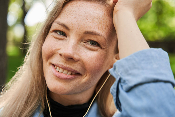Blonde caucasian woman wearing earphones listening music - Foto, Imagem