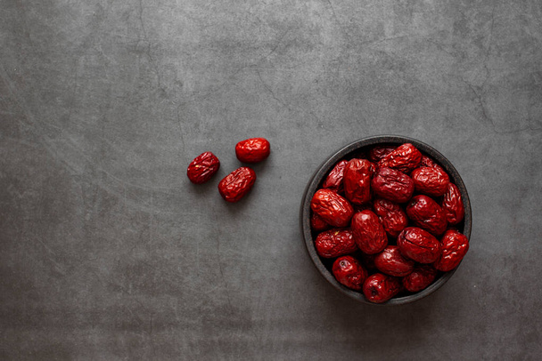 Сухий Джуцзюб, китайський сухий фрукт червоного кольору на темно-сірому фоні.. - Фото, зображення