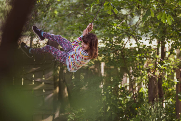 庭の木のスイングの幸せな女の子 - 写真・画像