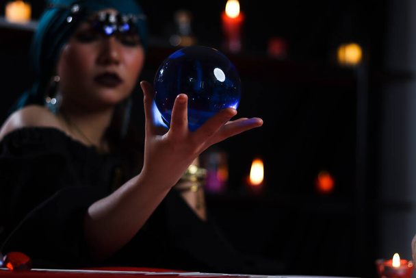 Boule de cristal à la main de mystérieuse magnifique femme diseuse de bonne aventure en robe noire, sorcière sombre essayer de lire l'avenir sur boule magique. - Photo, image