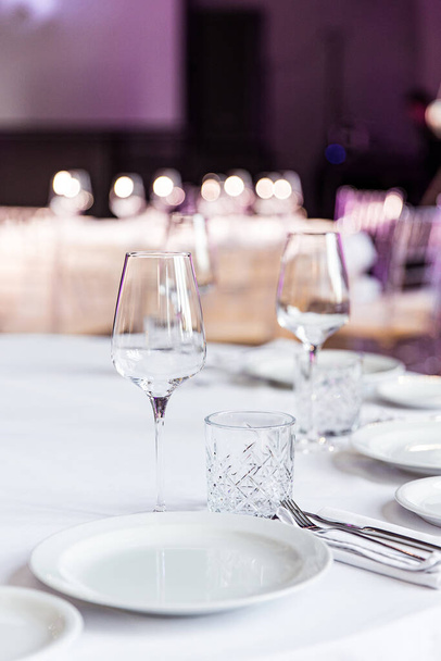 стильные пустые бокалы и тарелки при установке на элегантный стол для свадебного приема, питание в ресторане
 - Фото, изображение