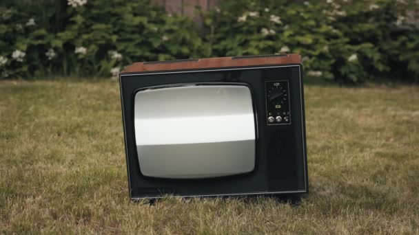 Η ρετρό παλιά τηλεόραση είναι στο δρόμο. Υπάρχει παρεμβολή στην οθόνη της συσκευής - Πλάνα, βίντεο