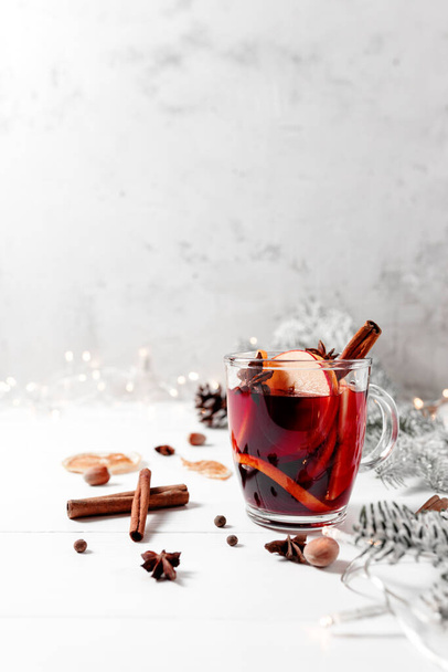 Χριστούγεννα. Γυάλινο κύπελλο του κρασιού σε λευκό γκρι φόντο τσιμέντου πίνακα - Φωτογραφία, εικόνα