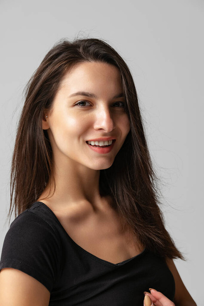 Close-up portrait of young beautiful smiling woman without makeup isolated over gray studio background. Natural beauty concept. - Fotografie, Obrázek