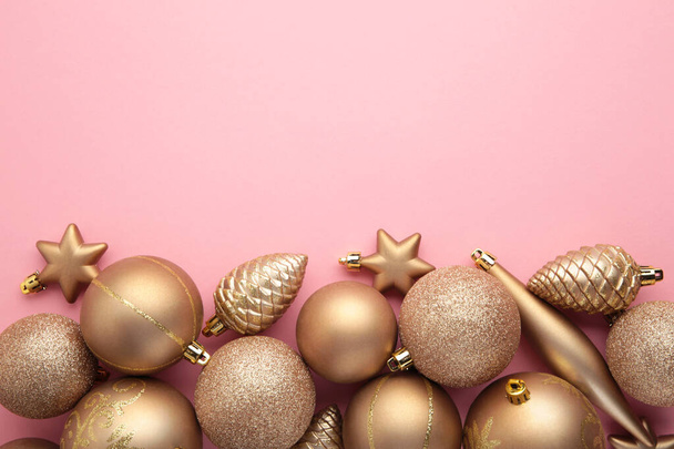 コピースペースとピンクの背景にゴールドクリスマスのおもちゃの装飾。新年の挨拶カード。ミニマルなスタイル。平置きだ。トップ表示 - 写真・画像