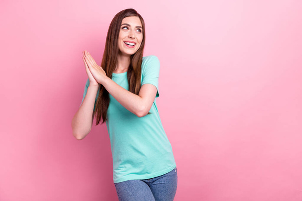 Photo of sweet cute young woman dressed turquoise t-shirt arms together looking empty space smiling isolated pink color background - Фото, зображення