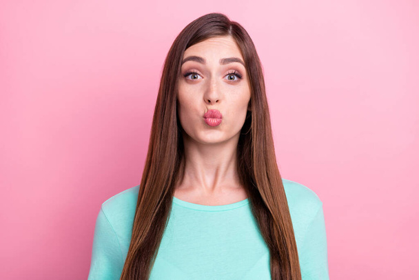 Photo of charming flirty young lady wear teal t-shirt sending you air kiss isolated pink color background - Φωτογραφία, εικόνα
