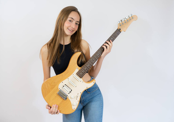 Beautiful girl playing electric guitar isolated over white background. - Foto, imagen