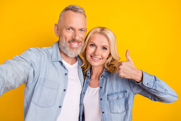 Photo of retired pensioner couple wife husband make selfie thumb up smile enjoy isolated on yellow color background - Фото, зображення