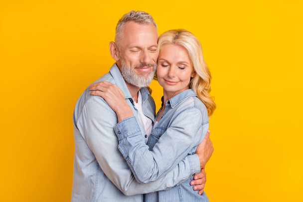 Photo of calm peaceful positive old couple hug embrace trust harmony enjoy isolated on yellow color background - Fotó, kép