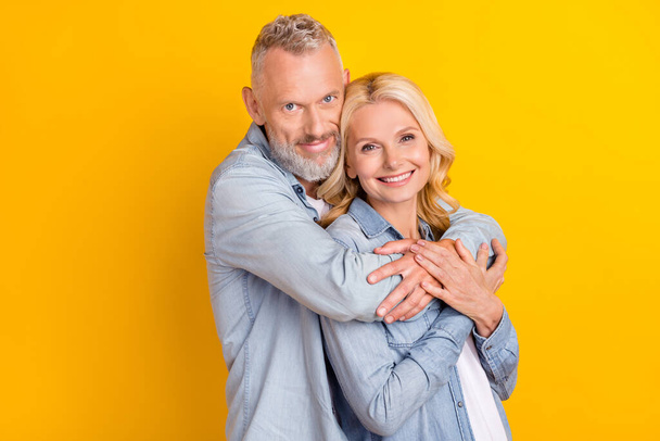 Photo of cheerful joyful happy old couple hug embrace care enjoy harmony hands isolated on yellow color background - Foto, Imagem