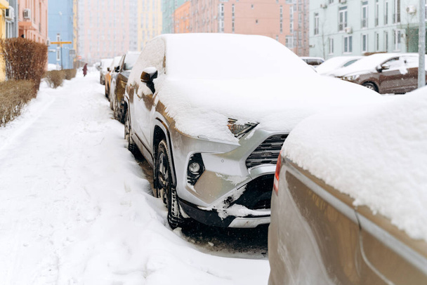 Вид на повну довжину ряду автомобілів під снігом після снігопаду. Автомобілі на засніженому паркінгу. Снігова зима і багато концепції снігу
 - Фото, зображення