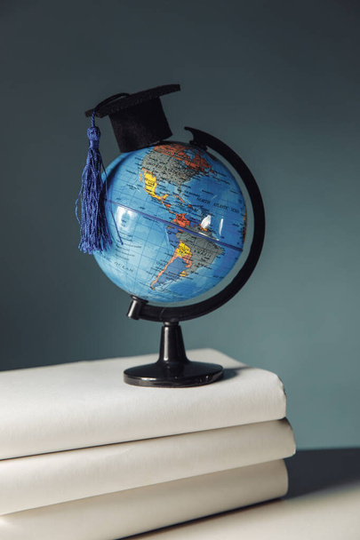 International education concept. Globe with graduation hat on books - Fotografie, Obrázek
