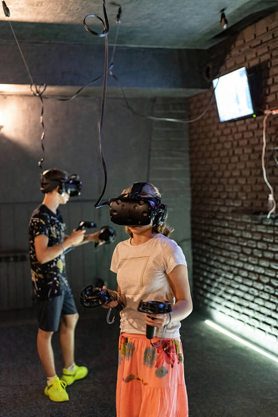 A guy and a girl in a VR helmet plays computer games. - Photo, Image
