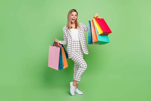 Full length body size view of attractive cheerful classy lady carrying new things having fun isolated over green color background - Photo, Image