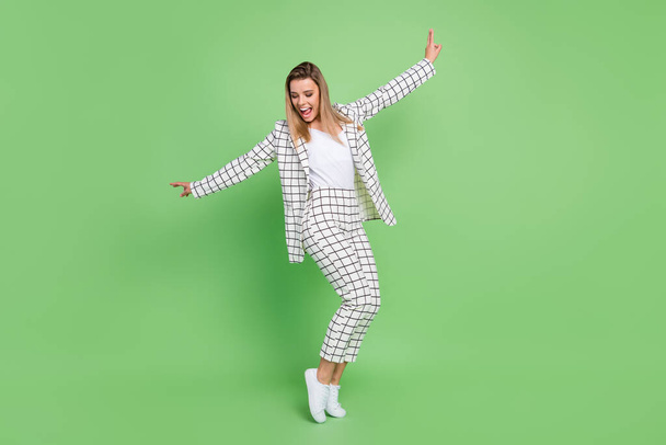 Full length photo of charming young funky woman dance good mood formalwear isolated on green color background - Foto, imagen