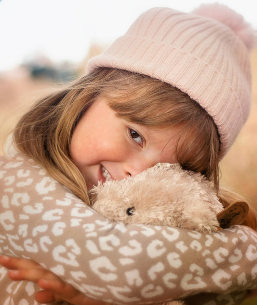 Cute little girl cuddling her teddy bear - Foto, afbeelding