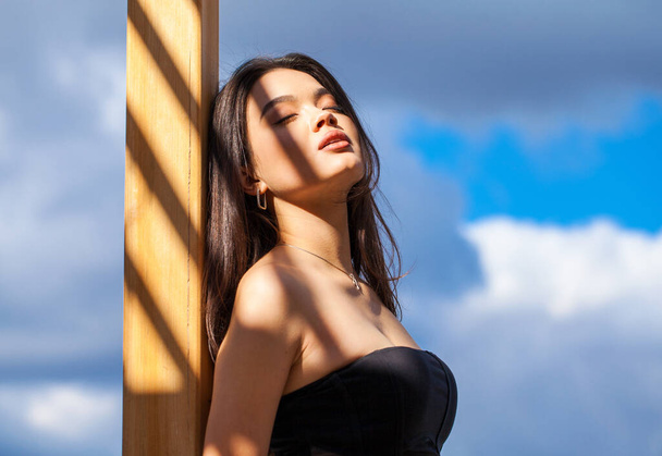 Portrait of a young beautiful girl on a background of blue sky - 写真・画像