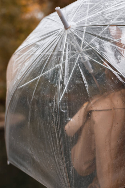 modello con ombrello trasparente sotto la pioggia in autunno. primo piano. vista posteriore - Foto, immagini