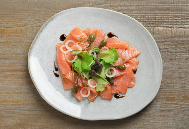 Delicious salmon carpaccio served on wooden table, top view - 写真・画像