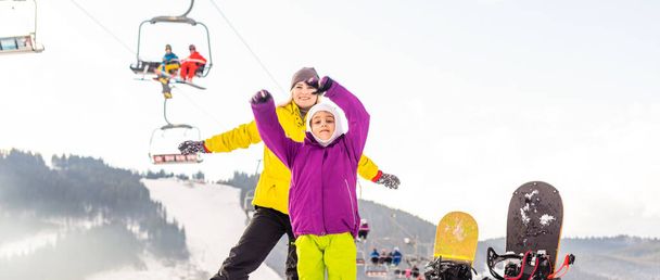 мати і дочка зі сноубордами на зимовому курорті
 - Фото, зображення