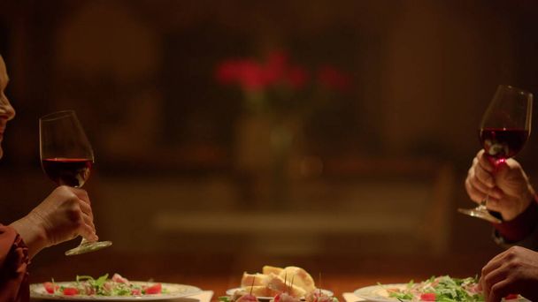 Vieux couple mains cliquetis verres à vin dîner romantique au restaurant - Photo, image