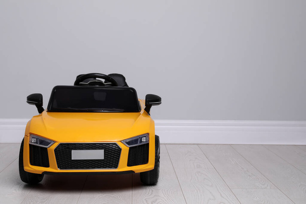 Child's electric toy car near light wall indoors. Space for text - Photo, Image