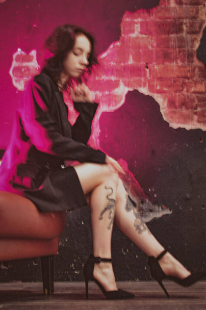 girl with tattoos in a jacket and sexy shoes in red neon - Zdjęcie, obraz