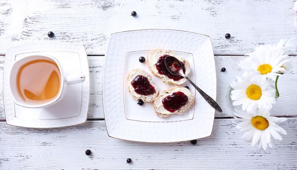Fresh toasts with homemade butter and blackcurrant jam on wooden background - Foto, immagini