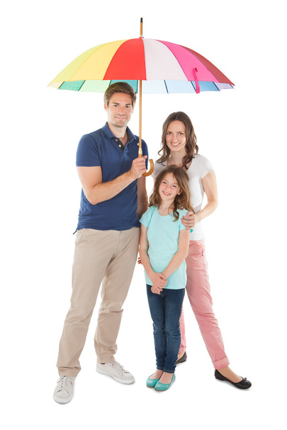 Family Standing Together with Umbrella - 写真・画像