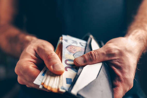 財布の中のユーロのスタック-購買力-男性の手を閉じる - 写真・画像