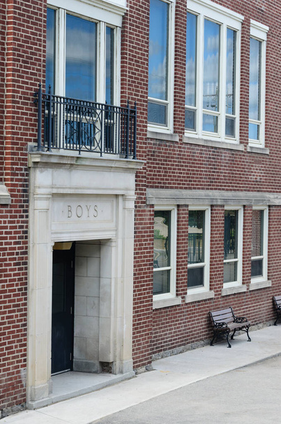 Außenfassade eines alten Schulgebäudes mit zwei Etagen einschließlich des abgetrennten Eingangs - Foto, Bild