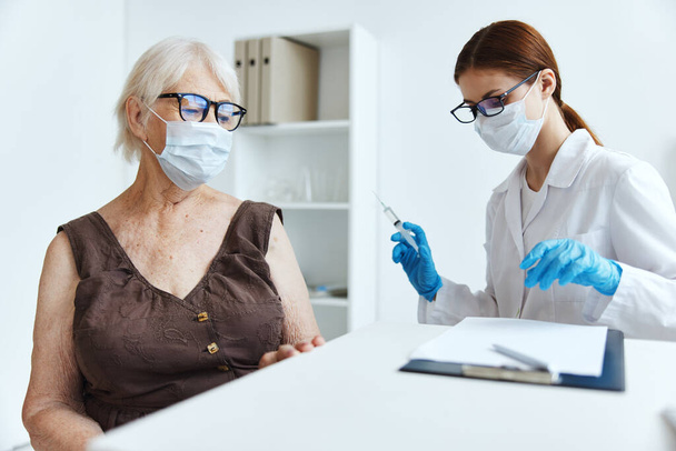 idős nő beteg ül a nővér mellett covid-19 útlevél - Fotó, kép