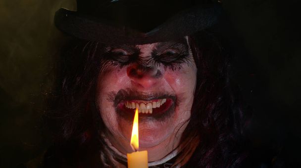 Przerażająca kobieta ze strasznym makijażem czarownicy Halloween w kostiumie co voodoo magiczne rytuały ze świecą - Zdjęcie, obraz