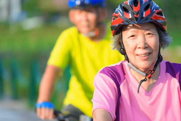 Szczęśliwa para seniorów trenująca na rowerach w parku - Zdjęcie, obraz