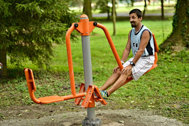Чоловік тренується на фітнес-машині
 - Фото, зображення