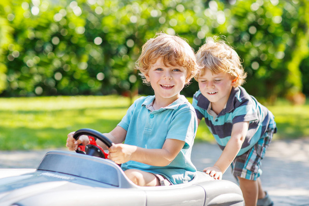 Deux garçons heureux frères et sœurs jouant avec la voiture jouet
 - Photo, image