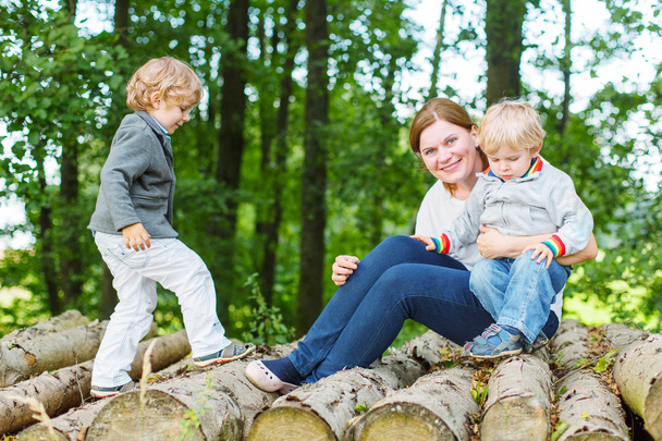Jeune mère et deux petits enfants s'amusent dans la forêt d'été
 - Photo, image