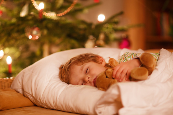 küçük şirin sarışın çocuk Noel ağacının altında uyuyor - Fotoğraf, Görsel