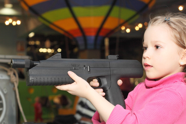 Girl playing with the big pistol - Foto, afbeelding