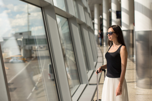 Mujer joven con equipaje de mano en el aeropuerto internacional
 - Foto, Imagen