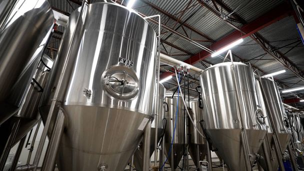 A low angle of beer stainless steel tanks in the factory - Foto, Imagem
