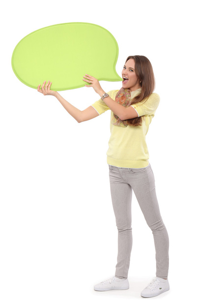 Portrait of a casual young woman holding blank card - over white background. - 写真・画像