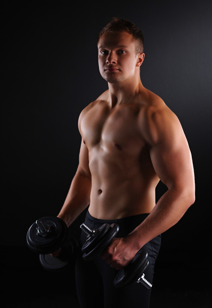 Fit muscular man exercising with dumbbell - Foto, immagini