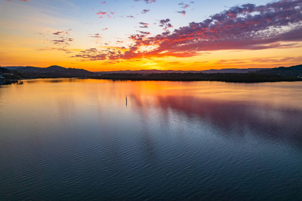 Aerial sunrise waterscape with high cloud reflecting on the Brisbane Water at Woy Woy on the Central Coast, NSW, Australia. - Photo, image