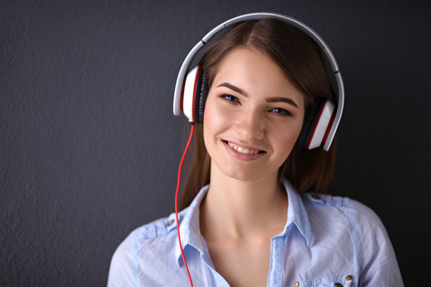 Smiling girl with headphones isolated on grey background - Fotoğraf, Görsel